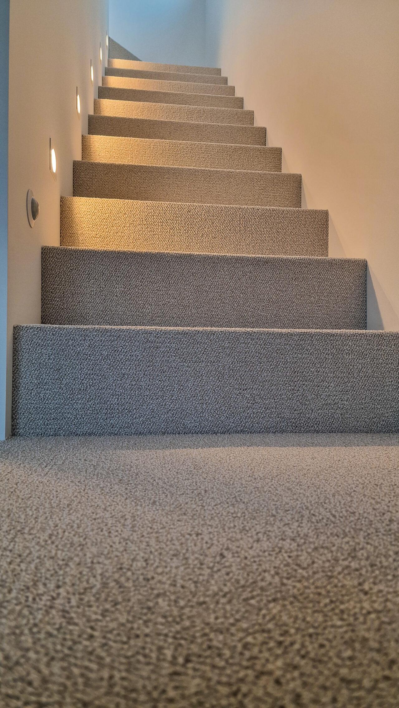 Šviesiu, kilpinių kilimu dengti laiptai. 1 nuotrauka